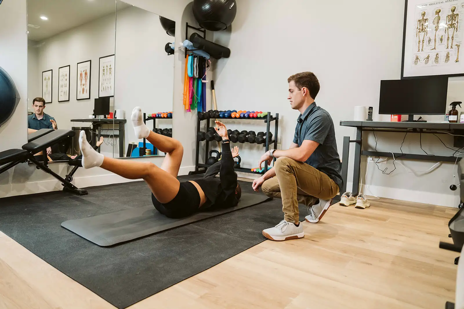 Dr. Hiebert guiding a patient through a floor-based corrective exercise at Summit Spine & Wellness