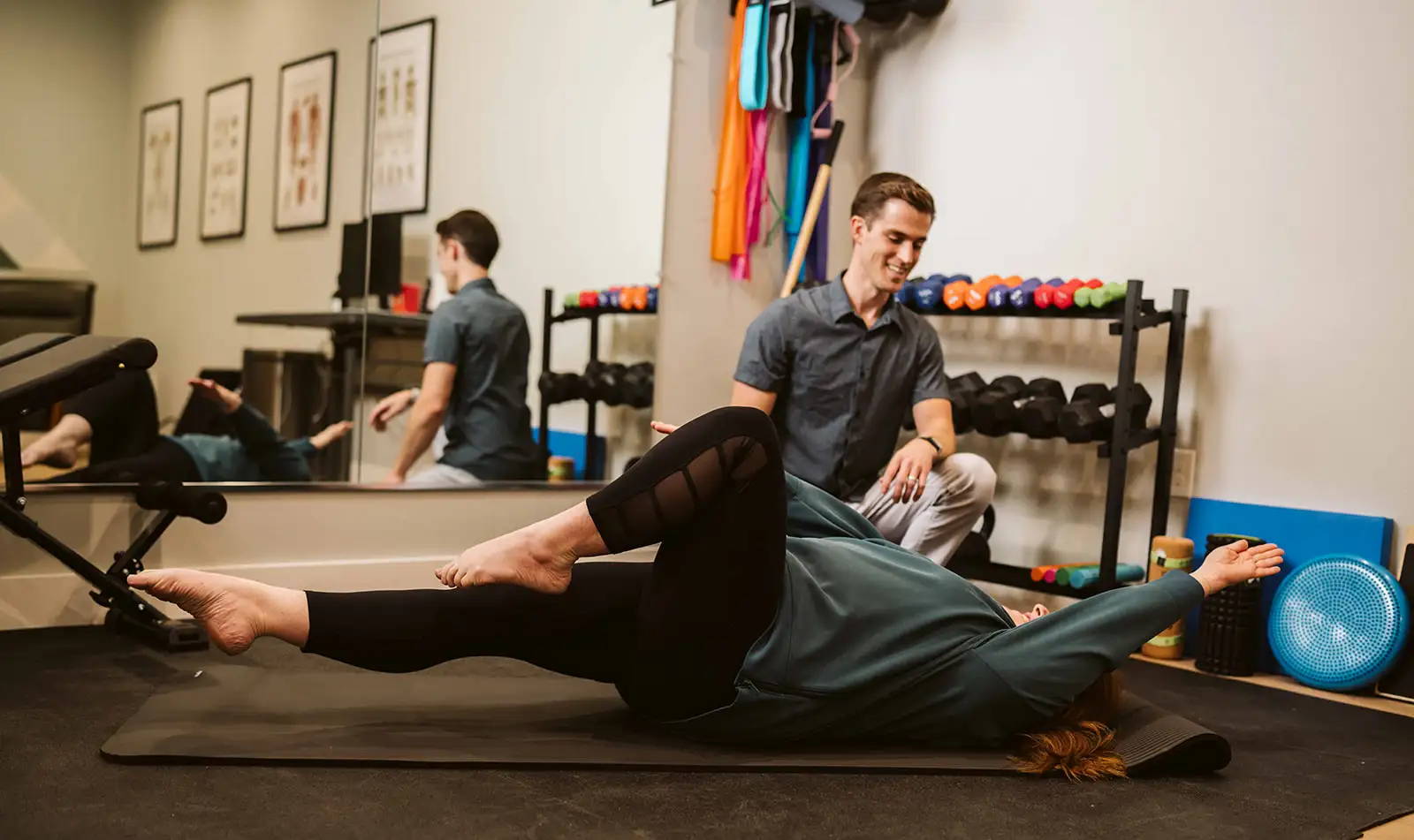 Dr. Hiebert guiding a patient through a floor-based rehabilitation exercise