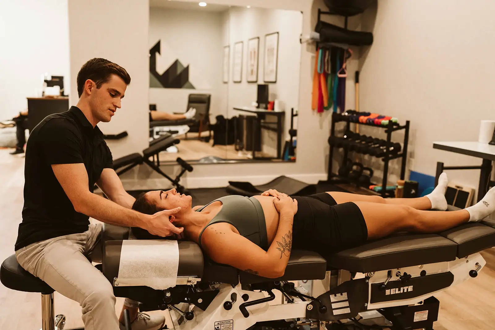 Dr. Hiebert performing a neck adjustment with a patient lying on a treatment table