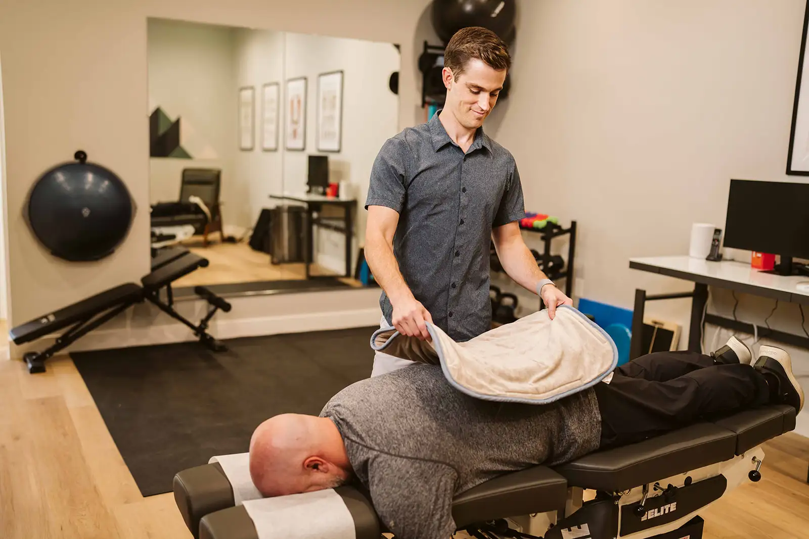 Dr. Hiebert placing a therapy wrap on a patient's back at Summit Spine & Wellness