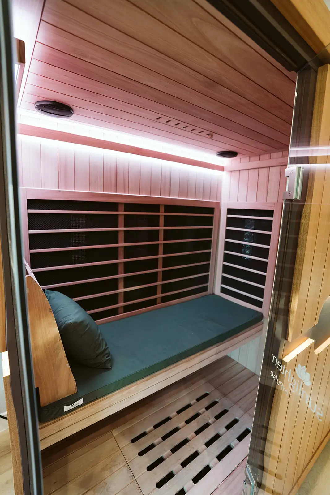 Interior of the wood-lined infrared sauna with padded seating